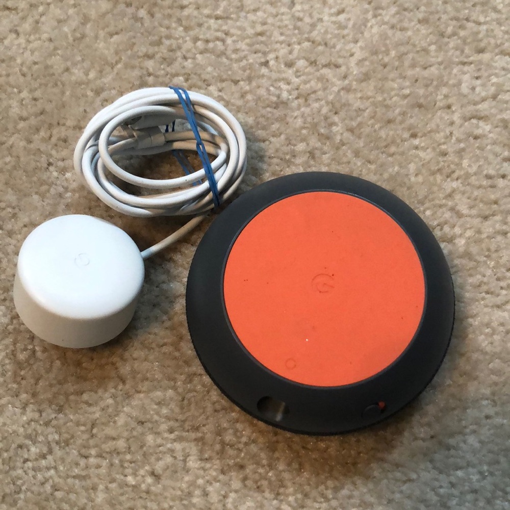 Google nest smart speaker with charger.
